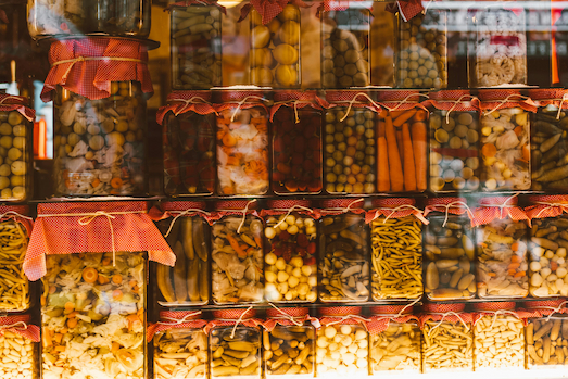 Many jars filled with different pickled food.