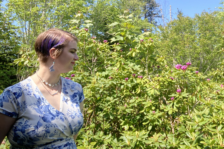 Mac in a blue and white dress in a garden.